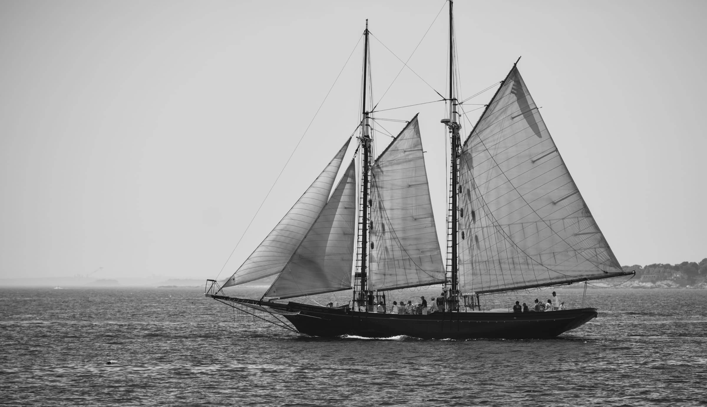 A two-masted schooner under full sail on open water.